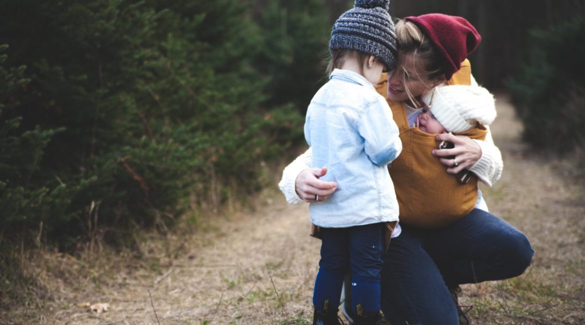 Madre en el bosque con sus dos hijos otoño